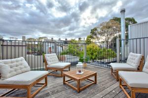 a patio with chairs and a table on a deck at 3 Bedrooms - Darling Harbour - Darghan Street 2 E-Bikes Included in Sydney