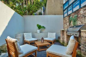 an outdoor patio with chairs and a grill at 3 Bedrooms - Darling Harbour - Ada Place in Sydney