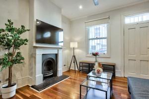 sala de estar con chimenea y mesa en 3 Bedrooms - Darling Harbour - Ada Place en Sídney