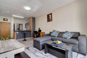 una sala de estar con un sofá y una mesa en GroundEazy beside Mall of Africa, en Midrand