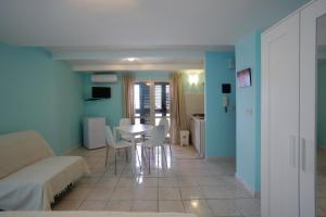 a living room with a couch and a table and chairs at Appartamento Topazio in Letojanni