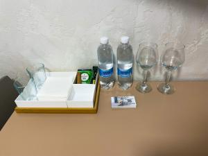 a table with two bottles and two glasses on it at Апартаменти MYFREEDOM поруч із метро Кловська in Kyiv +28 photos