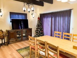 a dining room with a table and a christmas tree at Tree Village Karuizawa in Karuizawa