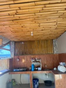a kitchen with a wooden ceiling and a tub at Coral Voice 1 Homestay & Lumbung in Gili Trawangan