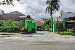 une rue dans une ville avec des bâtiments verts dans l'établissement OYO 90735 Palem Garden 2, à Tulungagung