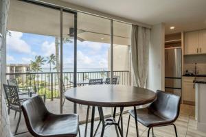a kitchen and dining room with a table and chairs at Hale Ono Loa 403- Top floor, Ocean view, & complete modern remodel in Kahana