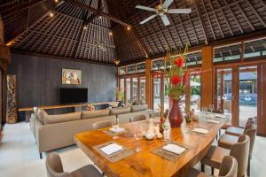 a dining room with a large wooden table and chairs at Amarterra Villas Resort Bali Nusa Dua, Autograph Collection in Nusa Dua