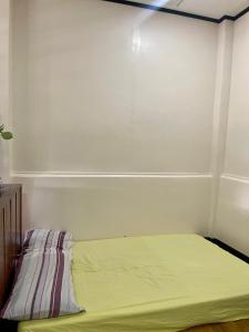 Bett in einem Zimmer mit gelbem Laken in der Unterkunft Maria Kulafu Kubo House Kinamaligan beside Eglin Gas Station 