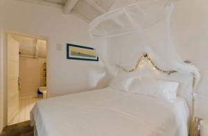 una camera da letto con un letto bianco e un bagno di Rustico al mare a Capo Mulini