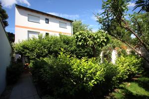 a house with bushes in front of a building at DAS Landhaus Klambauer - Apartmenthaus Thermennähe St Martins Therme in Frauenkirchen