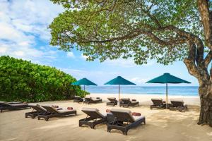 - un groupe de chaises longues et de parasols sur une plage dans l'établissement Amarterra Villas Resort Bali Nusa Dua, Autograph Collection, à Nusa Dua