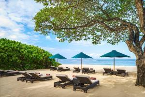a group of chairs and umbrellas on a beach at Amarterra Villas Resort Bali Nusa Dua, Autograph Collection in Nusa Dua