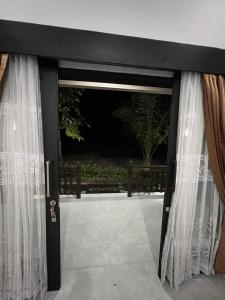 Una puerta en blanco y negro con cortinas. en Hidden Gem Uluwatu Apartments, en Uluwatu