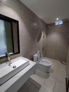 La salle de bains est pourvue d'un lavabo, de toilettes et d'un miroir. dans l'établissement khách sạn tina 5, à Cần Thơ