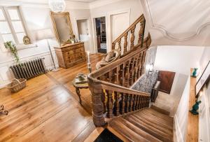 una escalera de caracol en una sala de estar con suelo de madera en Le Clos Marguerite - Maison d'Hôtes, en Ammerschwihr