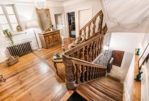 a spiral staircase in a living room with wooden floors at Le Clos Marguerite - Maison d'Hôtes in Ammerschwihr