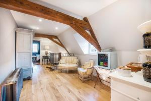 sala de estar con suelo de madera y techo con vigas. en Le Clos Marguerite - Maison d'Hôtes en Ammerschwihr