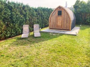 2 Stühle und ein Pavillon im Hof in der Unterkunft Lehmhäuschen mit Sauna in Tangermünde