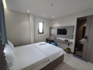 Dormitorio con cama, escritorio y TV en khách sạn tina 5, en Can Tho