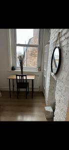einen Tisch und einen Stuhl in einem Zimmer mit Fenster in der Unterkunft St Andrews Mansions in London