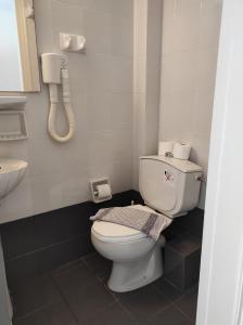 baño con aseo y teléfono en la pared en Filoxenia Beach Hotel en Rethymno Town