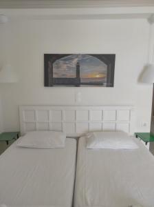 - une chambre avec 2 lits et une photo d'un phare dans l'établissement Filoxenia Beach Hotel, à Réthymnon