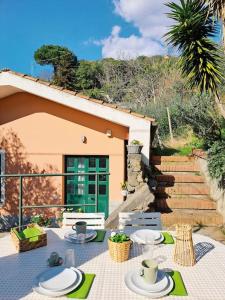 una casa y un patio con mesa y sillas en Casa Marina - Tenuta Calano, en Celle Ligure