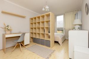 1 dormitorio con escritorio, 1 cama, escritorio y silla en Central Warsaw Apartment with Home Office by Renters, en Varsovia