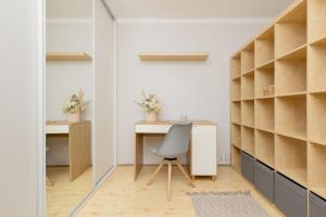 escritorio y silla en una habitación con estanterías en Central Warsaw Apartment with Home Office by Renters, en Varsovia
