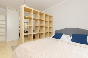 1 dormitorio con cama y estante para libros en Central Warsaw Apartment with Home Office by Renters, en Varsovia