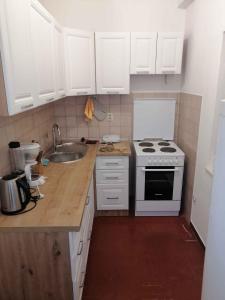 a kitchen with white cabinets and a stove and a sink at Holiday home in Starigrad-Paklenica 6797 in Seline