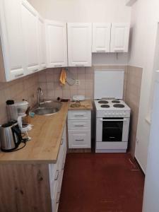 een keuken met witte kasten, een fornuis en een wastafel bij Holiday home in Starigrad-Paklenica 6797 in Seline