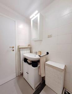 Baño blanco con lavabo y espejo en Casa Marina - Tenuta Calano, en Celle Ligure