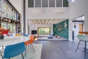ein Wohnzimmer mit einem Tisch und Stühlen in der Unterkunft Villa La Forêt • Piscine Parking & Wi-Fi in Sainte-Eulalie