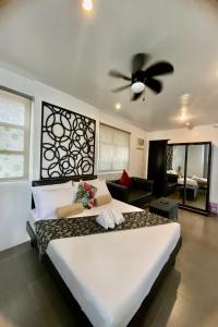 a bedroom with a large bed with a ceiling fan at Micasa Lodge in Coron