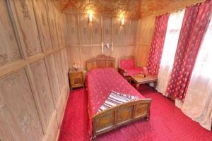 Schlafzimmer mit einem roten Bett und roten Vorhängen in der Unterkunft New kolohai group of houseboats in Srinagar