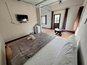 a bedroom with a large bed with a tv on the wall at Sawan Srang Nang Kaew in Takhop