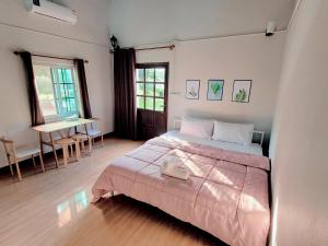 een slaapkamer met een bed en een tafel. bij Sawan Srang Nang Kaew in Ban Takhop