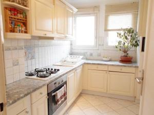 a kitchen with white cabinets and a stove at GREAT PARIS, private parking and balcony, 24 hours self checking, near Stade de France in Bondy