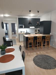 uma cozinha e sala de estar com mesa e cadeiras em 2 BR Apartment Peikontie em Oulu