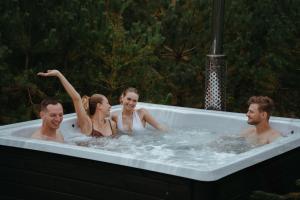 un grupo de personas sentadas en una bañera en Polana Gawrycha, domki nad jeziorem z widokiem en Suwałki