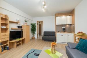a living room with a couch and a kitchen at Comfy Studio Turystyczna 300 m to the beach by Renters in Międzyzdroje