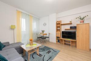 ein Wohnzimmer mit einem Sofa und einem Tisch in der Unterkunft Comfy Studio Turystyczna 300 m to the beach by Renters in Misdroy