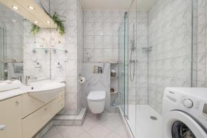 ein Bad mit einem WC, einem Waschbecken und einer Dusche in der Unterkunft Comfy Studio Turystyczna 300 m to the beach by Renters in Misdroy