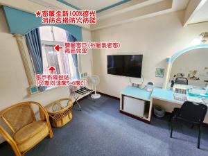 a living room with a desk and a television at Hua Ku Hotel in Tainan