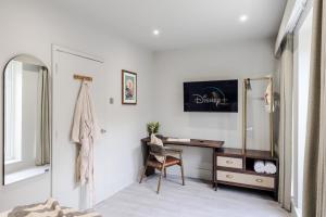 um quarto branco com uma secretária e uma cadeira em Tooting - Your Apartment em Londres