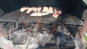 a grill with meat and vegetables cooking on it at La gura sobei in Mărăcineni +6 photos