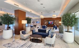 eine Lobby mit einem blauen Sofa und Stühlen in der Unterkunft Address Opera - Lux 3 BR with Full Burj Khalifa View near Dubai Mall in Dubai