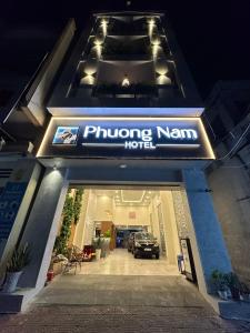 a building with a car parked in a driveway at Phuong Nam Hotel An Giang in Long Xuyên