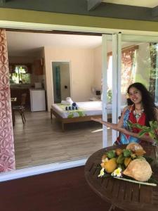 a woman standing in a room with a plate of food at Dominic's Beach Bungalow in Muri